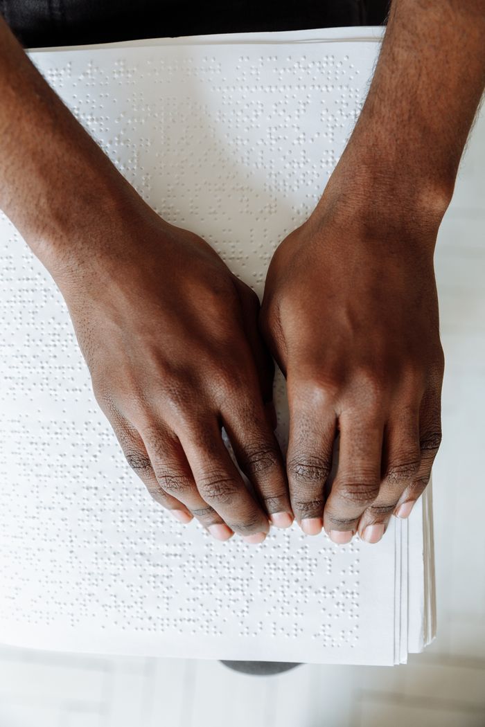 Mastering the First Impression: Your intriguing post title goes here Close-up of hands feeling Braille, highlighting assistive technology for visually impaired.
